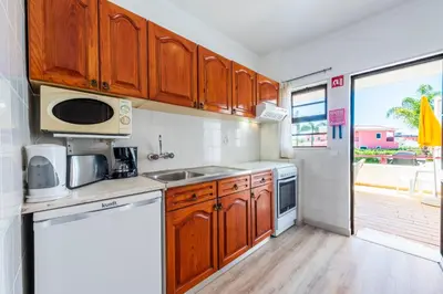 a kitchen with wooden cabinets and a sink at Solgarve in Quarteira