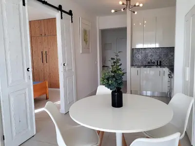 a white dining room with a white table and white chairs at Atlantico 8- Vista Mar, Ar-Condicionado, 80mt Praia, Wifi in Quarteira