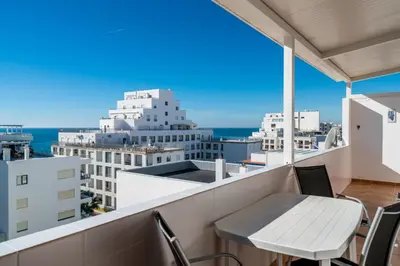 a balcony with chairs and a view of the city at Akisol Quarteira Gun in Quarteira