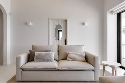 a living room with a couch with two pillows at Casa Pé na Areia- Unique Spot- Beach front by DreamvillasAlbufeira in Albufeira