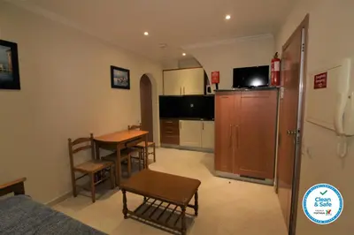 a living room with a table and a kitchen at Beach Waves - Albufeira in Albufeira