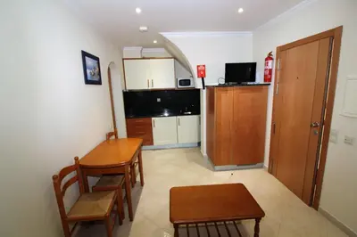 a kitchen with a table and chairs in a room at Beach Waves - Albufeira in Albufeira