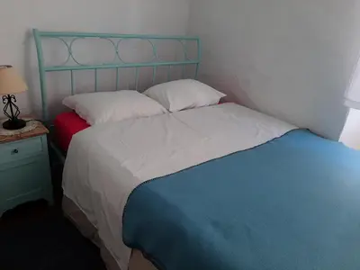 a bedroom with a bed with a blue head board at Traditional House in Historical Center of Faro in Faro