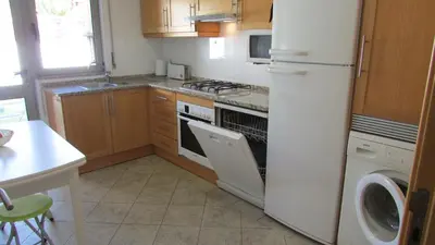a kitchen with a white refrigerator and a dishwasher at Pomba Branca (4-6 per.) Piscina, 500m Praia in Albufeira