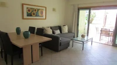 a living room with a couch and a table at Pomba Branca (4-6 per.) Piscina, 500m Praia in Albufeira