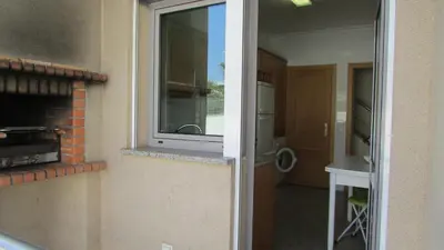 a door to a kitchen with a sink and a window at Pomba Branca (4-6 per.) Piscina, 500m Praia in Albufeira
