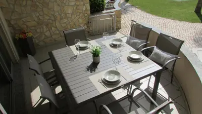 a table with glasses and flowers on a patio at Pomba Branca (4-6 per.) Piscina, 500m Praia in Albufeira