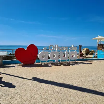 a red heart sitting on the beach next to a sign at Pomba Branca (4-6 per.) Piscina, 500m Praia in Albufeira