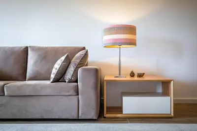 a living room with a couch and a table with a lamp at Victory Village 3B in Quinta do Lago