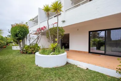 a white house with plants in a yard at Victory Village 3B in Quinta do Lago
