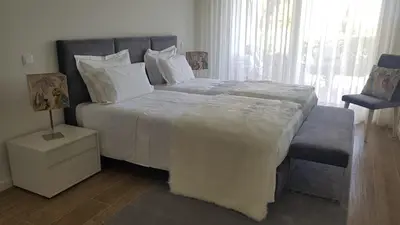 a bedroom with a large white bed and a window at Victory Village 3B in Quinta do Lago