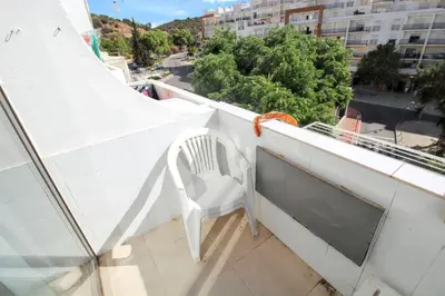 a white chair sitting on the ledge of a balcony at Comfortable studio in Albufeira - 20 m² - Pleasant balcony in Albufeira