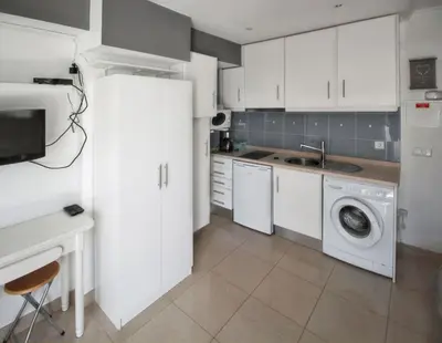 a kitchen with white cabinets and a washing machine at Comfortable studio in Albufeira - 20 m² - Pleasant balcony in Albufeira