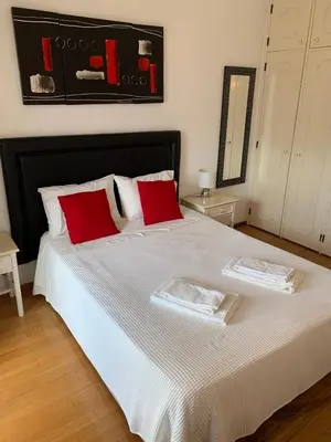 a bedroom with a large bed with red pillows at A CASINHA - Pateo Aldeia in Albufeira