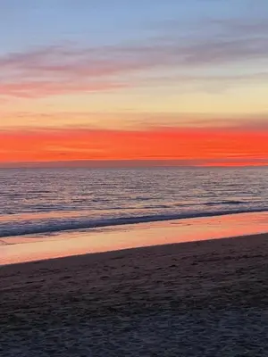 a view of a beach with the ocean at sunset at A CASINHA - Pateo Aldeia in Albufeira