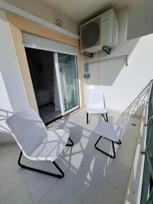 a dining room with a table and chairs and a window at Apartamentos Roja Sol in Albufeira