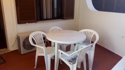 a white table and four chairs around a white table at Casal das Alfarrobeiras, 7 in Vilamoura