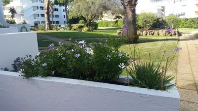 a garden with purple flowers in a white wall at Casal das Alfarrobeiras, 7 in Vilamoura