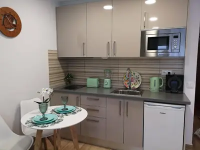 a kitchen with a small table and a microwave at Lux Home in Albufeira