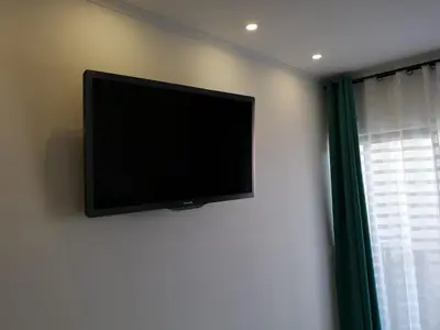 a flat screen tv on a wall next to a window at Lux Home in Albufeira
