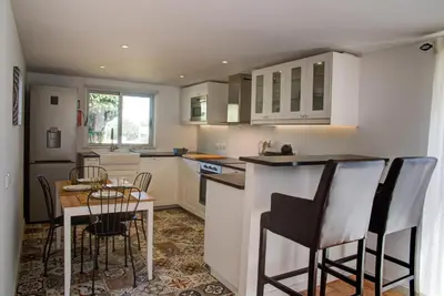 a kitchen with a table and chairs and a kitchen with white cabinets at CASA GRAZINA in Boliqueime