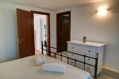 a bedroom with a bed with a dresser and a mirror at CASA GRAZINA in Boliqueime