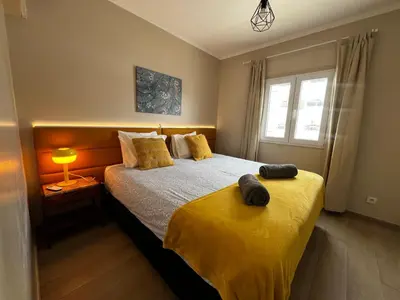 a bedroom with a bed with yellow sheets and a window at Vista Mar e Terra in Albufeira