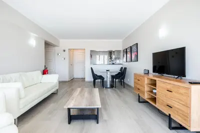 a living room with a white couch and a flat screen tv at Vista Mar e Terra in Albufeira