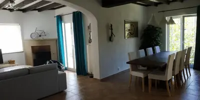 a dining room with a table and chairs and a couch at Casa Albacor in Vilamoura