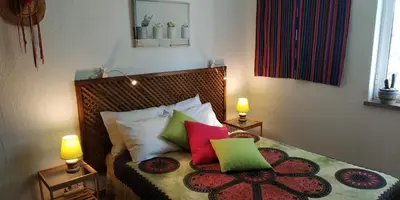 a bedroom with a bed with colorful pillows on it at Casa Albacor in Vilamoura