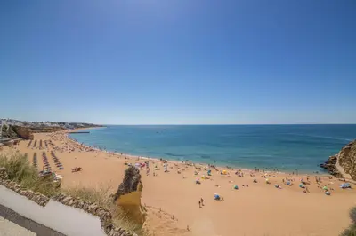 a group of people on a beach near the ocean at Albufeira Beach Studio in Albufeira