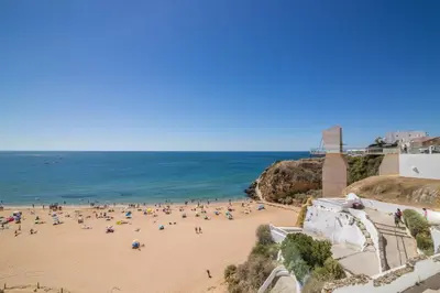 a group of people on a beach near the ocean at Albufeira Beach Studio in Albufeira