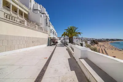 a sidewalk next to a beach and a building at Albufeira Beach Studio in Albufeira