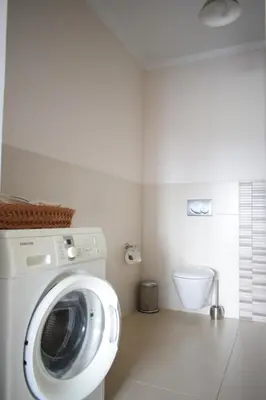 a washing machine in a bathroom with a toilet at Estúdio-Gambelas in Faro
