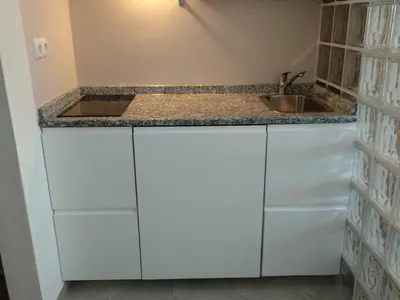 a kitchen with white cabinets and a sink at Estúdio-Gambelas in Faro