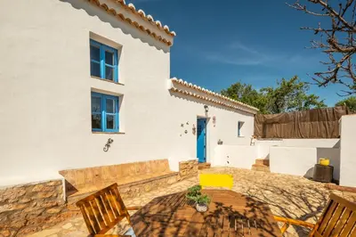 a patio with a table and chairs in front of a house at Villa Monte Algarvio - Private Heated Pool - wifi in Tunes