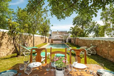 a table with chairs and a pool in a yard at Villa Monte Algarvio - Private Heated Pool - wifi in Tunes