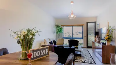 a living room with a table with a home sign on it at Parque Atlântico com Vista Mar in Quarteira