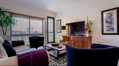 a living room with a couch and a tv at Parque Atlântico com Vista Mar in Quarteira