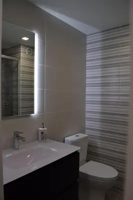 a bathroom with a toilet and a sink and a mirror at magnifico apartamento in Albufeira