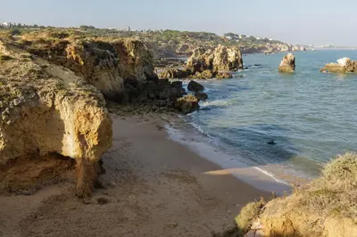 a beach with some rocks and the ocean at Beach Design House Sao Rafael in Albufeira