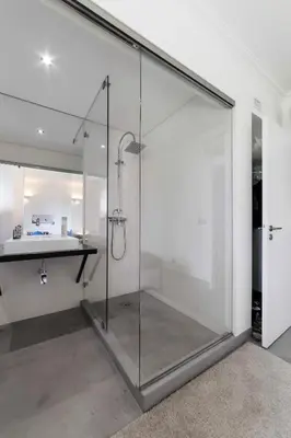 a glass shower in a white bathroom with a counter at Beach Design House Sao Rafael in Albufeira