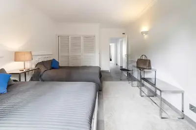 a bedroom with two beds and a table and a couch at Beach Design House Sao Rafael in Albufeira