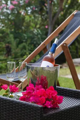 a bottle of wine and flowers on a table with glasses at Beach Design House Sao Rafael in Albufeira