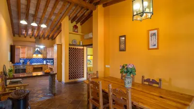 a kitchen and dining room with a long wooden table at Casinhas Wheelchair friendly in Boliqueime