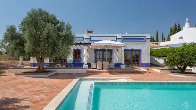a villa with a swimming pool in front of a house at Casinhas Wheelchair friendly in Boliqueime