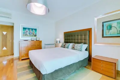 a bedroom with a large bed and a dresser at OnJ Vilamoura in Quarteira