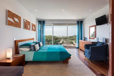 a bedroom with a bed and a large window at Romy in Vale do Lobo