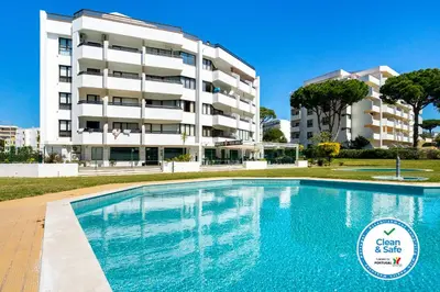 a swimming pool in front of a building at WHome | Vilamoura Sunny Apartment in Quarteira