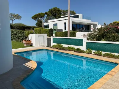a swimming pool in front of a house at Casa Nicho in Vale do Lobo